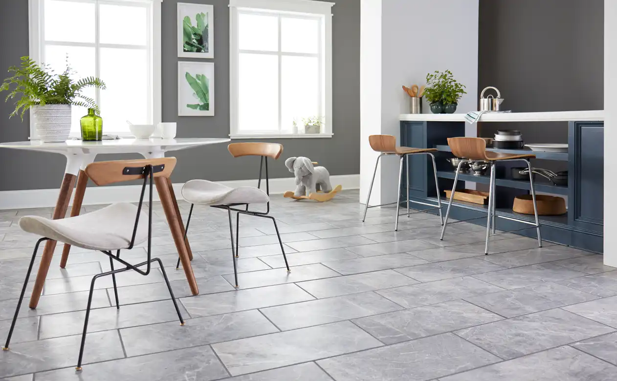 Gray tile flooring in a kitchen with a bar and dining table